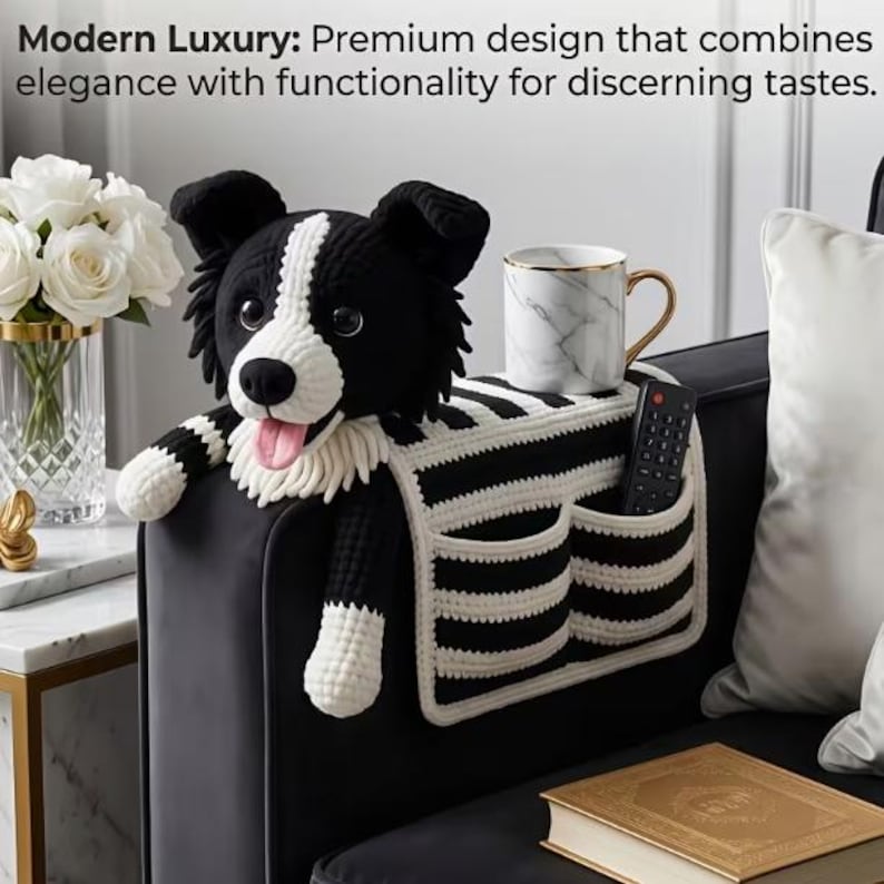 Puede incluir: Un organizador de reposabrazos de sof&aacute; tejido en crochet blanco y negro con forma de perro, que incluye una cabeza de perro de peluche, dos bolsillos y un patr&oacute;n de rayas. Sostiene una taza con patr&oacute;n de m&aacute;rmol blanco y un mando negro.