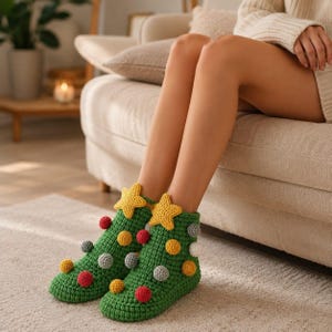 May include: A pair of green crochet ankle socks featuring a textured knit pattern. The socks are decorated with small, round, multi-colored pom-poms in red, yellow, and grey, and each sock is topped with a prominent yellow crochet star.