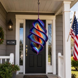 Peut inclure: Une décoration suspendue en crochet en forme de spirale aux couleurs vives. Le dégradé de couleurs passe du bleu profond et du violet aux oranges et jaunes chauds. Accroché devant une porte noire avec un panneau "WELCOME".