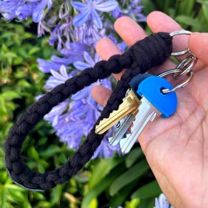 May include: Black braided key chain with a blue key fob and three keys attached.