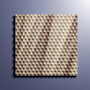 May include: A square wooden panel with a repeating honeycomb pattern. The wood has a light brown color with visible grain, and the hexagonal cells create a textured surface. The panel is set against a blue background.