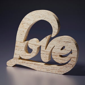 May include: A wooden decorative piece in the shape of a heart with the word "Love" carved into it. The wood has a light, natural color with visible grain. The piece is freestanding and sits on a reflective surface.