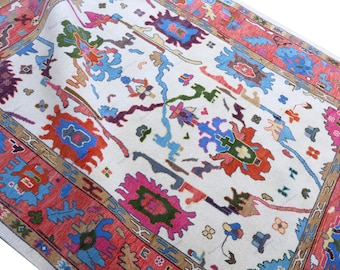 May include: A detailed, hand-knotted rug with a cream-colored field and a vibrant border. The rug features a complex pattern of colorful, abstract floral and geometric designs in shades of red, blue, green, and pink. The border is a rich red with intricate detailing.