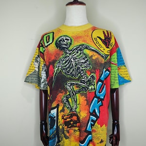 May include: Yellow, red, blue, and green graphic t-shirt with a skeleton skateboarding and the text "Body Glove" and "S.U.K.E.S."