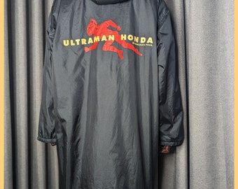 May include: Black hooded jacket with a red and yellow "ULTRAMAN HONDA" logo on the back. The jacket has a yellow "World Standard" logo on the bottom with the text "Modern Design Concepts" and the social media handle "@mustache_Jebron".