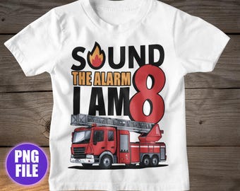 May include: White t-shirt with a red fire truck graphic and the text "SOUND THE ALARM I AM 8". The design includes a flame and the number 8 in red. A fun birthday shirt for an eight-year-old.