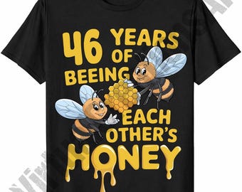 May include: Black t-shirt with a yellow graphic that reads "46 YEARS OF BEING EACH OTHER'S HONEY." The graphic features two cartoon bees holding a honeycomb. The text and illustrations are in yellow.