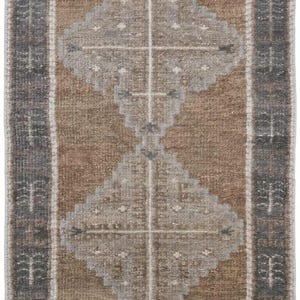 May include: A rectangular runner rug featuring a brown field with two large, light gray diamond-shaped medallions centered vertically. The borders are dark gray with repeating white tree-like motifs and thin white lines separating the sections.