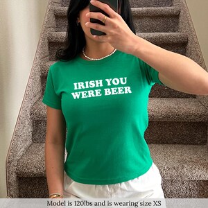 May include: A green t-shirt with white text that reads "Irish You Were Beer".