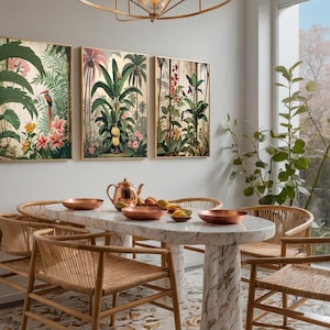 Three framed botanical art prints showcasing tropical scenes with green foliage, pink flowers, and birds. A marble dining table with copper bowls and woven chairs are set in a dining room. The table is approximately 150 cm long.