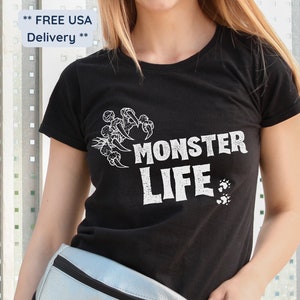May include: Black t-shirt with a white graphic of a monster paw print and the text "Monster Life".