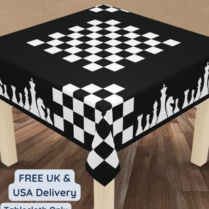 Puede incluir: Un mantel negro y blanco con temática de ajedrez. El centro presenta un patrón de cuadros blancos y negros, con un borde de siluetas de piezas de ajedrez blancas. El texto "Tablecloth Only" es visible.