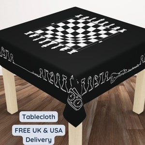 Puede incluir: Mantel de mesa a cuadros blanco y negro con piezas de ajedrez alrededor del borde. El mantel está sobre una mesa de madera con el texto "Tablecloth", "FREE UK & USA Delivery" impreso en el mantel.