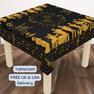 May include: Black and gold tablecloth with a musical theme. The design features silhouettes of musicians playing instruments and musical notes. The text "Tablecloth" is visible in the lower left corner.
