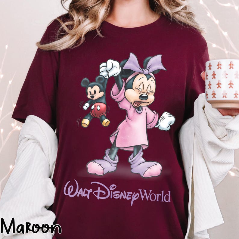 May include: Maroon t-shirt featuring a Minnie Mouse graphic in a pink dress and bow, with Mickey Mouse. The text "Walt Disney World" is printed below the characters. The word "Maroon" is printed at the bottom left.