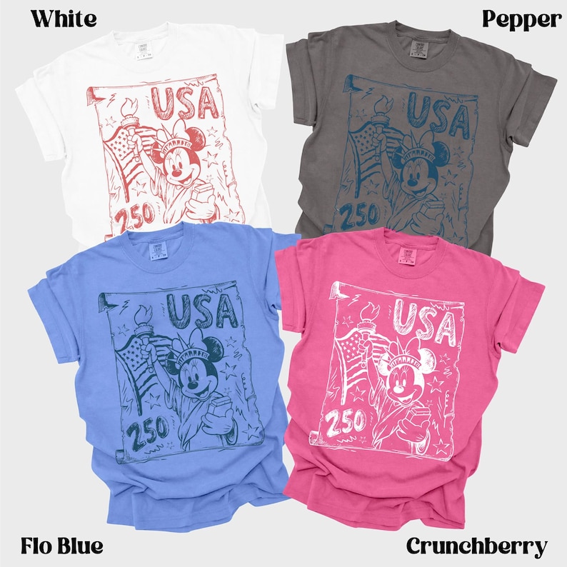 May include: Four t-shirts in white, pepper, flo blue, and crunchberry. Each shirt features a graphic of Mickey Mouse holding a torch and American flag, with the word "USA" and the number "250".