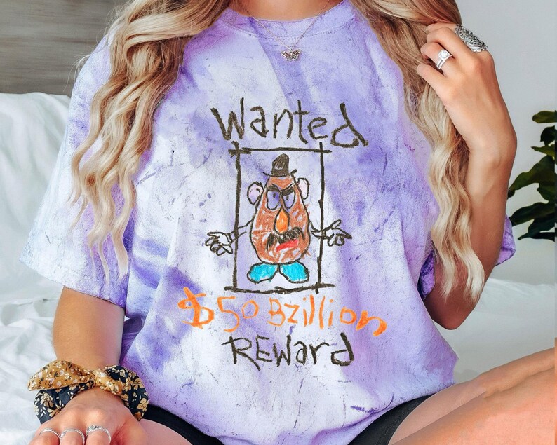 K&ouml;nnte beinhalten: Lilafarbenes T-Shirt im Tie-Dye-Look mit einer Cartoon-Zeichnung von Mr. Potato Head und dem Text "Gesucht 50 Milliarden Belohnung".