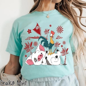 May include: A light blue t-shirt featuring a graphic of a rooster, a pig, and a sailboat with red accents. The text "Chalky Mint" is at the bottom of the shirt.