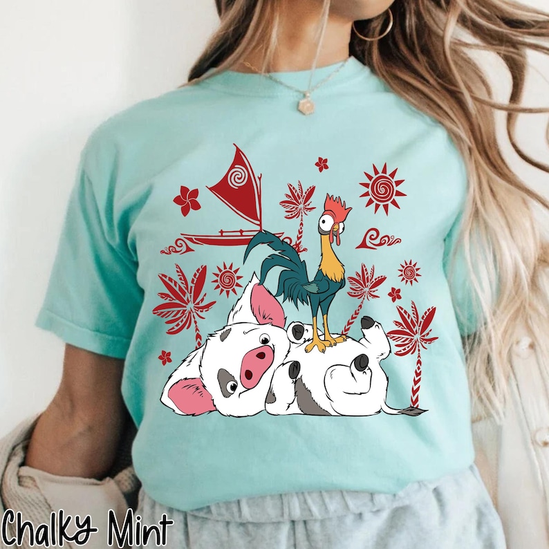 May include: A light blue t-shirt featuring a graphic of a rooster, a pig, and a sailboat with red accents. The text "Chalky Mint" is at the bottom of the shirt.