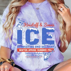 May include: Purple tie-dye t-shirt with a graphic of Kristoff and Sven's Ice Harvesting and Delivery. The graphic features a snowman, reindeer, and the text "Kristoff & Sven's ICE HARVESTING AND DELIVERY WINTER; SPRING SUMMER FALL Delivering throughout Arendelle Kingdom CONTACT SVEN FOR DETAILS".