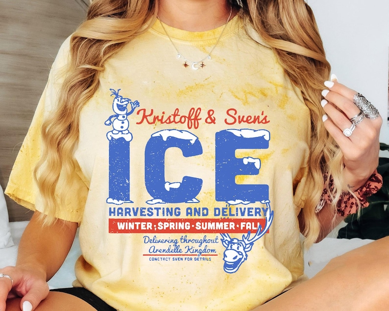 May include: A yellow tie-dye t-shirt with a vintage-style graphic of Olaf from Frozen. The graphic says "Kristoff & Sven's ICE" and "Harvesting and Delivery Winter; Spring Summer Fall" with a reindeer illustration. The text also says "Delivering throughout Arendelle Kingdom Contact Sven for details."