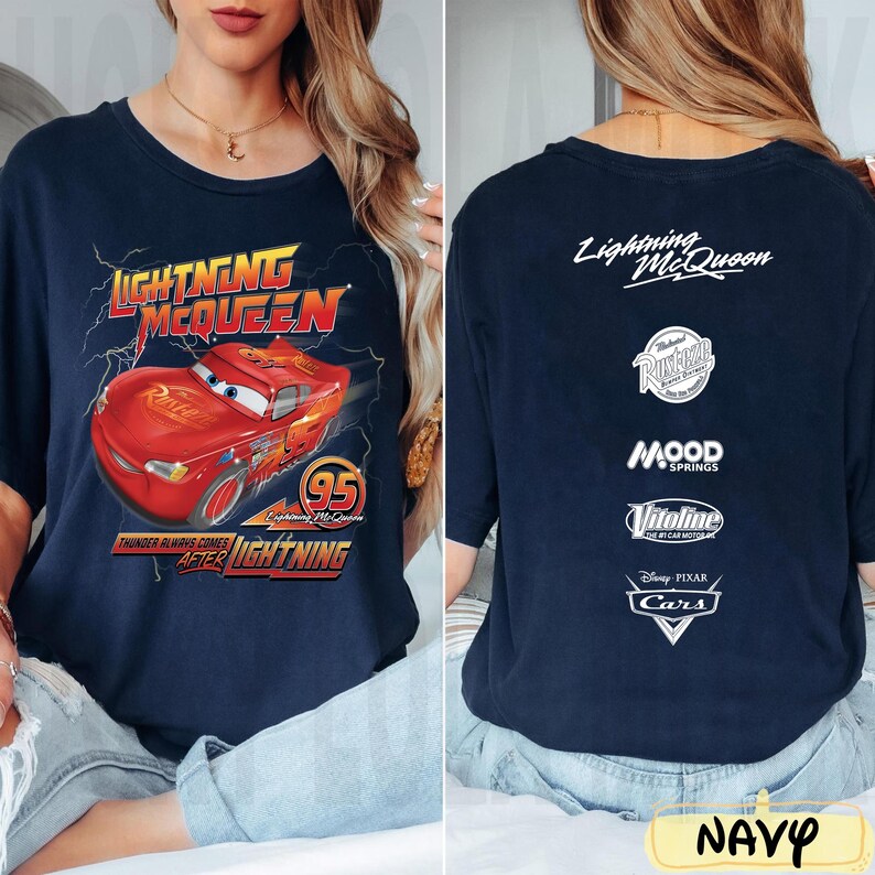 May include: Navy blue t-shirt featuring Lightning McQueen from the Disney Pixar Cars movie. The front graphic shows the red race car with text "Lightning McQueen" and "95". The back displays the text "Lightning McQueen" and various logos.