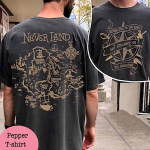 May include: A black t-shirt with a map of Neverland printed on the back. The map includes landmarks like Skull Rock, Mermaid Lagoon, and Pirate Cove. The text "NEVER LAND" is printed on the front of the shirt.