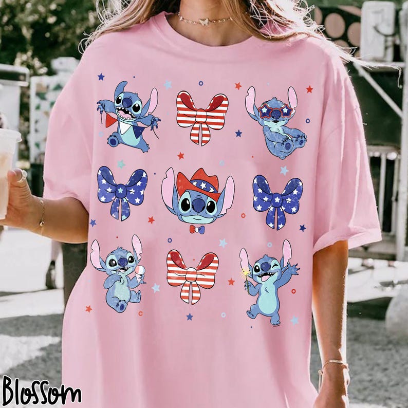 May include: Pink t-shirt with a pattern of the character Stitch in various poses with patriotic bows and stars. The word "Blossom" is printed at the bottom left corner of the shirt.
