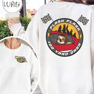 May include: White sweatshirt with a graphic featuring a sloth in a red race car, the words "Flash" and "100 Yard Dash", and checkered flags. The design is repeated on the front. The word "White" is in a circle at the top left.