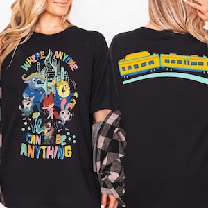 Pu&ograve; includere: T-shirt nero con grafica di personaggi dei cartoni animati colorati e la scritta "WHERE ANYONE CAN BE ANYTHING". Il retro della maglietta presenta un disegno di treno giallo e blu. Un design divertente e stravagante.