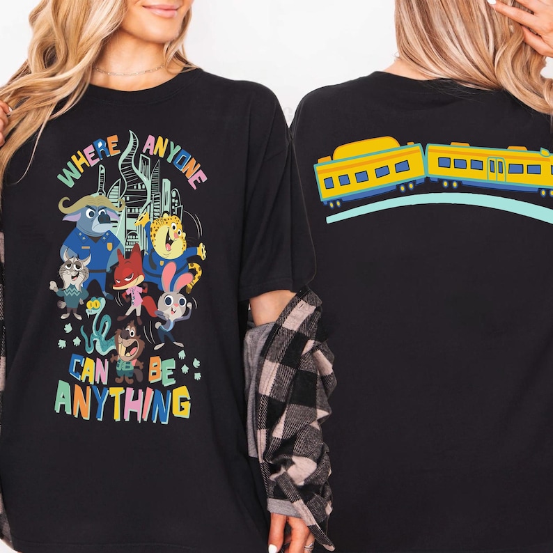 Pu&ograve; includere: T-shirt nero con grafica di personaggi dei cartoni animati colorati e la scritta "WHERE ANYONE CAN BE ANYTHING". Il retro della maglietta presenta un disegno di treno giallo e blu. Un design divertente e stravagante.