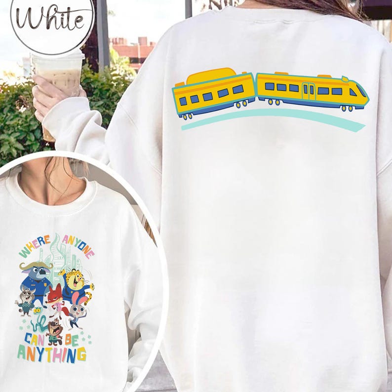 Pu&ograve; includere: Felpa bianca con un design a treno a fumetti giallo e blu sul retro. La parte anteriore presenta una grafica colorata con la scritta "WHERE ANYONE CAN BE ANYTHING".