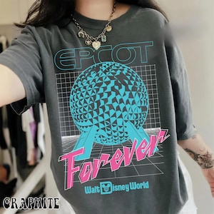 Op de afbeelding: Grafietgrijs T-shirt met een retro design. Het ontwerp toont de tekst "EPCOT Forever" in blauw en roze, een geometrische bol en het Walt Disney World-logo. Het T-shirt is casual en heeft korte mouwen.