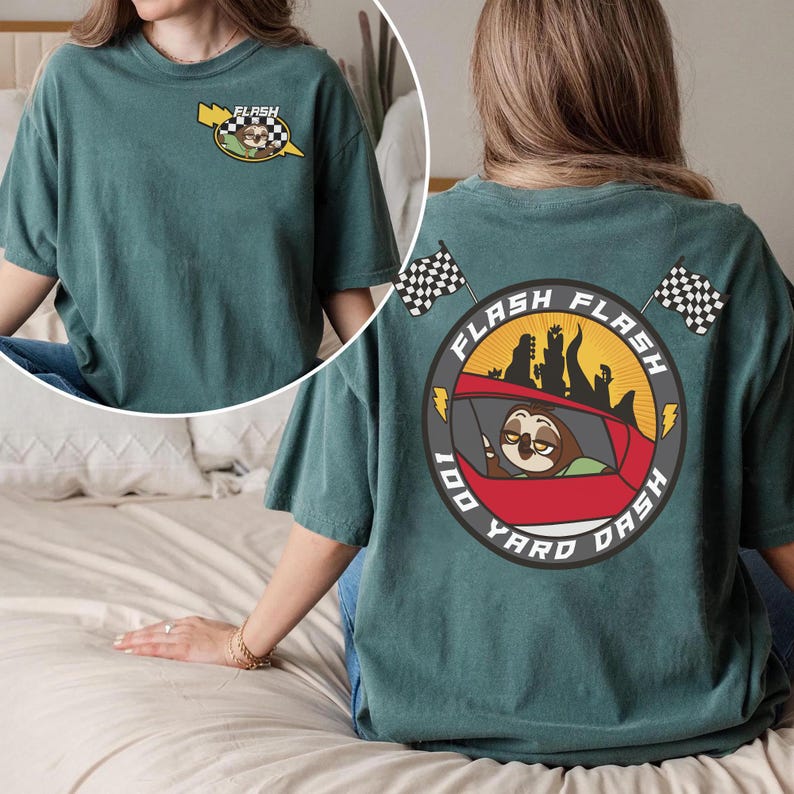 May include: Teal-colored t-shirt featuring a cartoon sloth in a race car with the text "FLASH" and "100 YARD DASH". The design includes checkered flags and lightning bolts. The shirt is a comfortable, casual style.