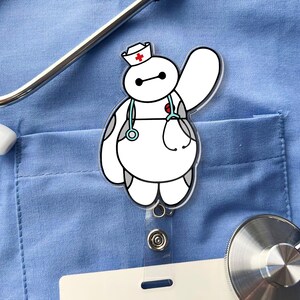 May include: A white, rounded character badge reel featuring a nurse hat with a red cross, a light blue stethoscope draped around its neck, and one arm raised in a wave. The character has black eyes and gray accents on its body.