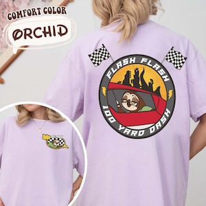 May include: Light purple t-shirt with a graphic of a sloth in a race car, the text "Flash 100 Yard Dash", and two checkered flags. The shirt also has the text "Comfort Color Orchid".