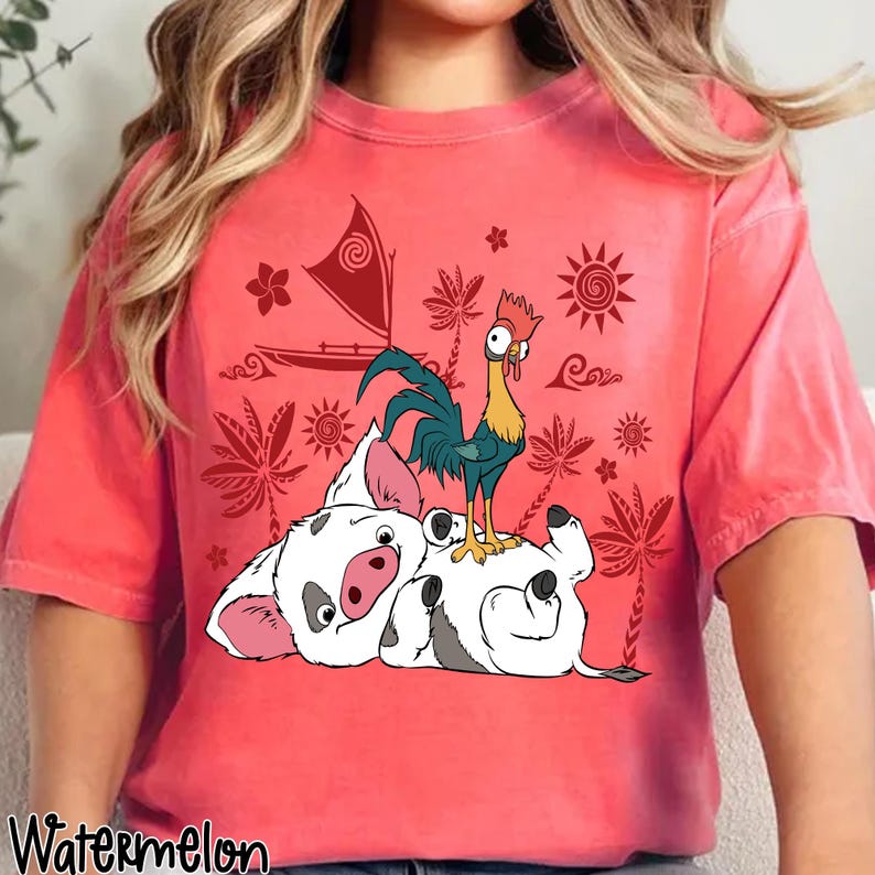 May include: A coral-colored t-shirt featuring a graphic of a pig and a rooster, with a sailboat and tropical elements. The word "Watermelon" is printed at the bottom left. The design is in shades of white, black, red, yellow, and blue.