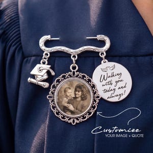 May include: A silver-toned graduation pin with a photo pendant, a mortarboard charm, and a circular charm with the text "Walking with you today and always!". The pin is attached to a navy blue garment. The text "Customize. YOUR IMAGE + QUOTE" is also visible.