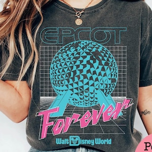 Op de afbeelding: Donkergrijs t-shirt met een retro design. De tekst "EPCOT Forever" is in roze en blauw, met een geometrische bol en het Walt Disney World logo. Het ontwerp heeft een vintage thema.