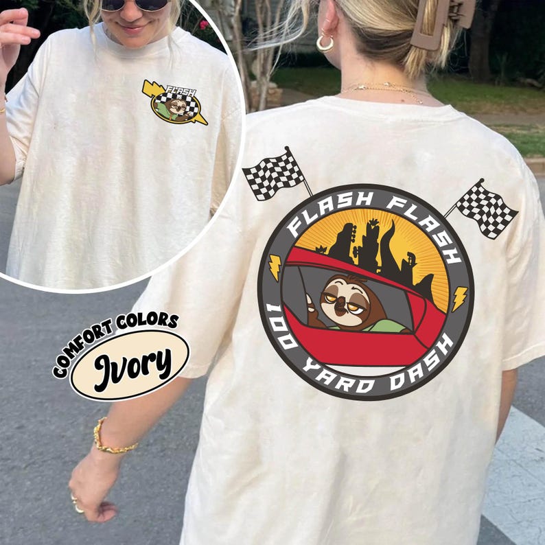 May include: Ivory-colored t-shirt with a graphic on the front and back. The back graphic features a sloth in a red car with the words "Flash 100 Yard Dash." The front graphic has a sloth in a car with the word "Flash."