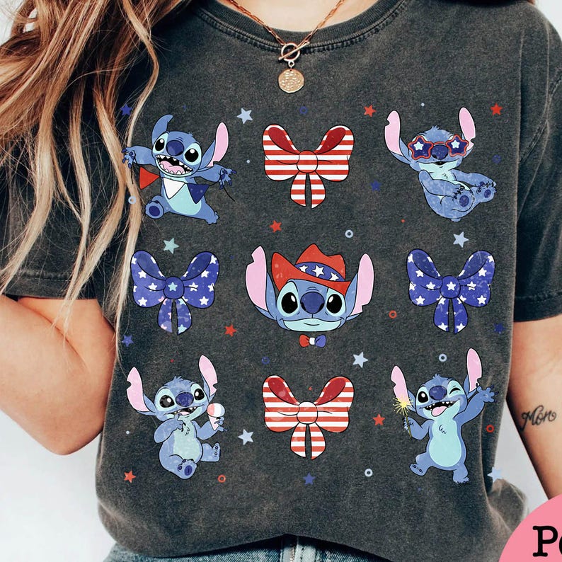 May include: Dark grey t-shirt with a collage of Stitch characters in patriotic poses. Stitch is shown with a cape, sunglasses, and a cowboy hat, alongside red, white, and blue bows and stars. The shirt has a vintage, worn appearance.