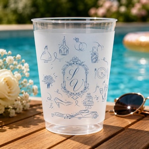 May include: A frosted plastic cup featuring blue line art illustrations of wedding icons including a church, rings, a dress, a bouquet, a cake, and a vintage car. The center displays an ornate oval frame with the initials SV and the date 16.11.2025.