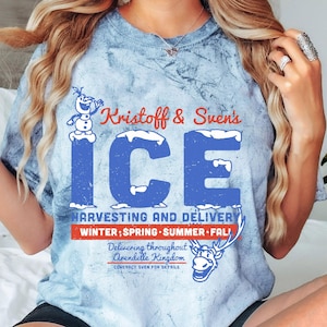 May include: A blue tie-dye t-shirt with a graphic of Olaf and Sven from the movie Frozen. The graphic says "Kristoff & Sven's ICE HARVESTING AND DELIVERY WINTER; SPRING SUMMER FALL Delivering throughout Arendelle Kingdom CONTACT SVEN FOR DETAILS".