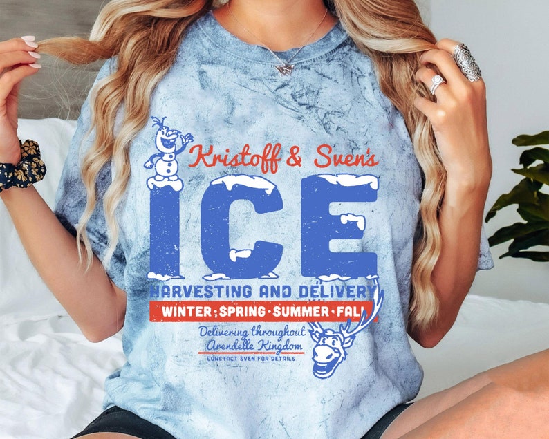 May include: A blue tie-dye t-shirt with a graphic of Olaf and Sven from the movie Frozen. The graphic says "Kristoff & Sven's ICE HARVESTING AND DELIVERY WINTER; SPRING SUMMER FALL Delivering throughout Arendelle Kingdom CONTACT SVEN FOR DETAILS".