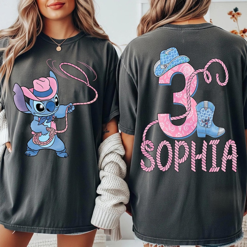 May include: Dark gray t-shirts featuring a cartoon Stitch character in a cowboy hat and a pink lasso. The back of the shirt has a pink number 3, a cowboy boot, and the name "Sophia" in pink.