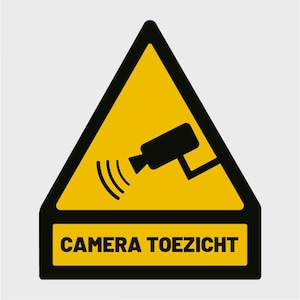Op de afbeelding: Een geel driehoekig waarschuwingsbord met een zwarte rand en een zwart silhouet van een beveiligingscamera met een bewegingssensor. Het bord heeft de tekst "CAMERA TOEZICHT" in zwarte letters.