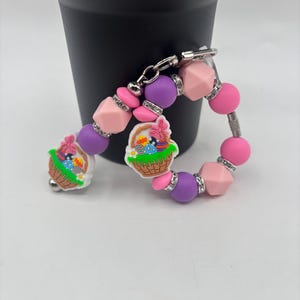 Könnte beinhalten: Eine weiße Keramik-Tasse mit schwarzem Henkel und dem Text "But First, Coffee" in schwarzer, handschriftlicher Schrift. Die Tasse steht auf einer weißen Oberfläche.