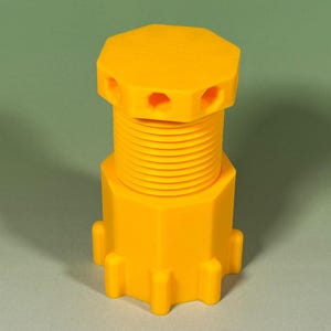 May include: A vibrant yellow cylindrical component with a threaded central section and a hexagonal base and top. The top features several small holes. Likely a part of a larger mechanism or device.