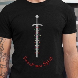 May include: A black t-shirt with a silver sword decorated with colorful Christmas lights. The text "Sword-mas Spirit" is written in red below the sword.