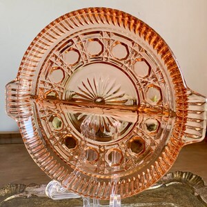 Op de afbeelding: Een vintage roze glazen serveerschaal met een gegolfde rand en een diamantpatroon. De schaal heeft een centraal stervormig ontwerp en een ring van achthoeken rond de rand.